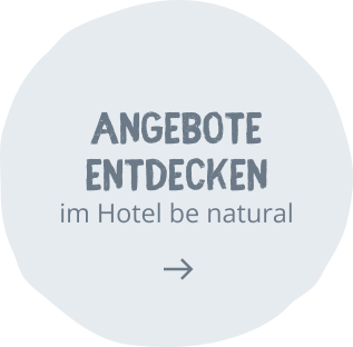 Round pale blue promo badge with the text 'SOMMER-ANGEBOTE' and 'im be natural' and a rightward arrow, signaling a summer offers CTA.