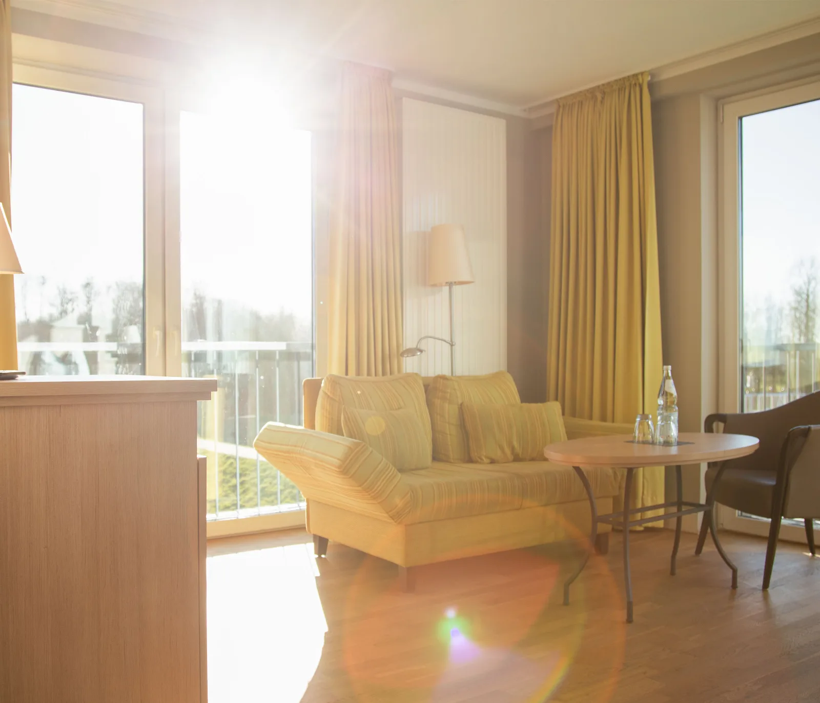 Sonnige Sitzecke mit Sofa und Tisch im Komfortzimmer des be natural in Tönning