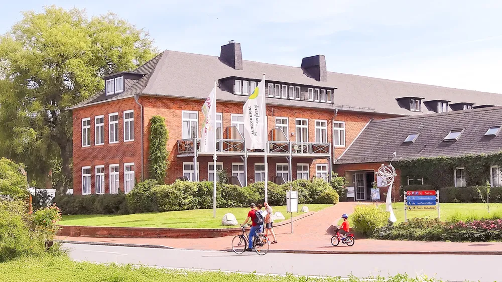 Außenansicht des Hotels be active in Tönning mit Radfahrern davor