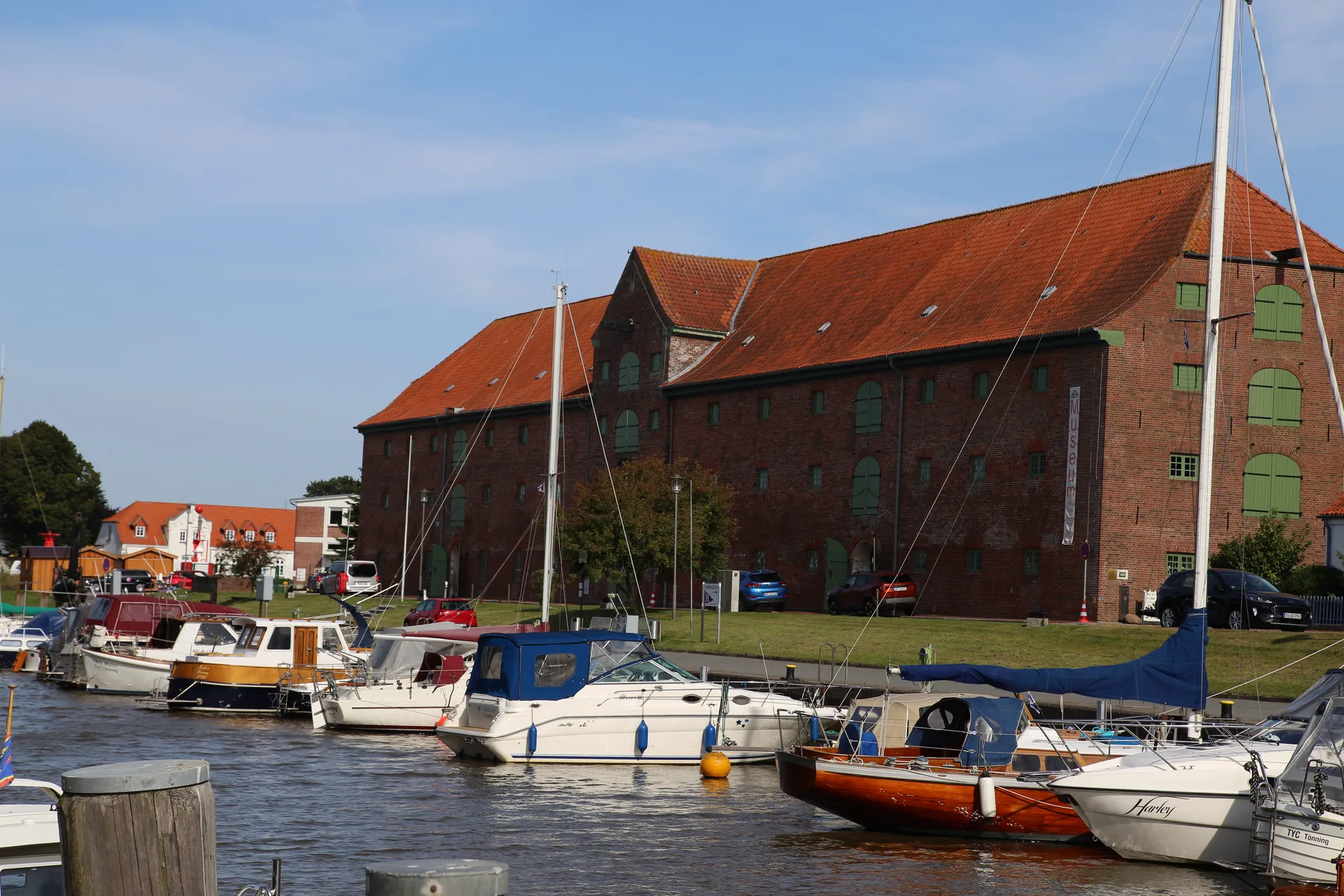Das historische Packhaus am Tönninger Hafen, davor Segel- und Motorboote im Hafenbecken