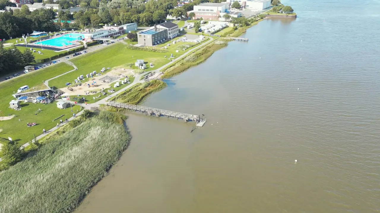 Luftbild: langer Steg an der Eider, Deich, Freibad und das Hotel be natural in Tönning