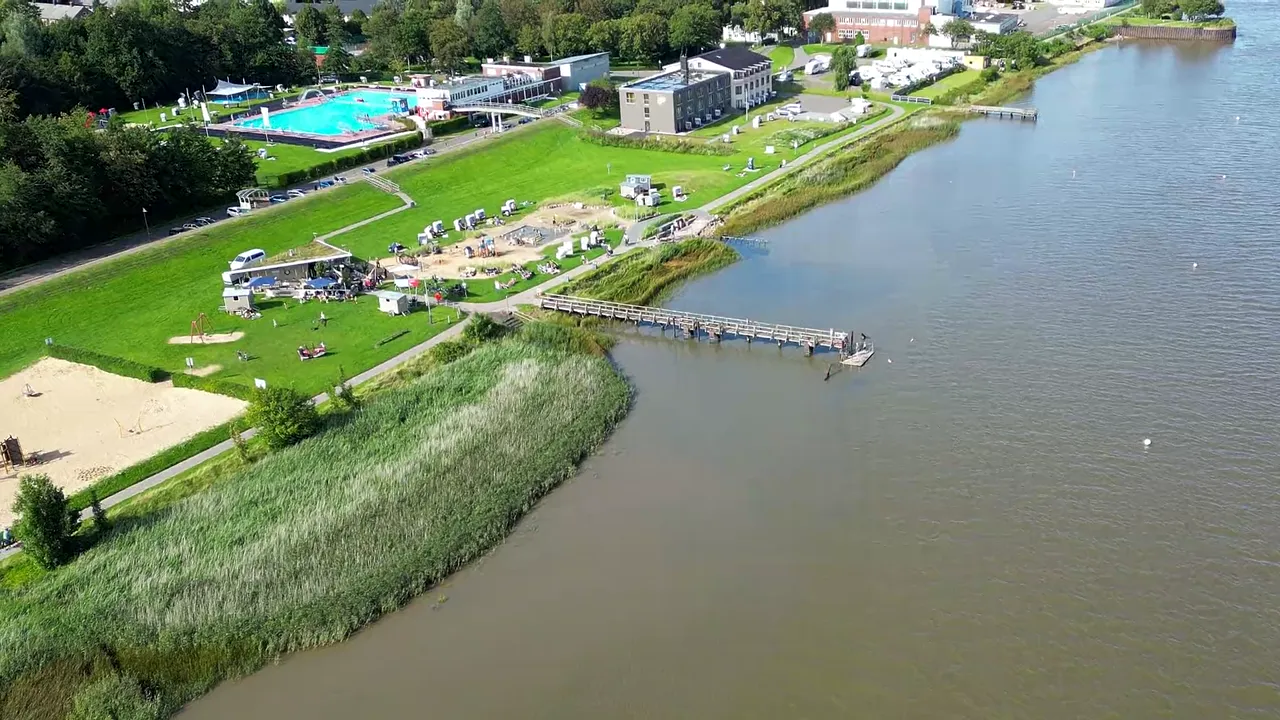 Luftbild: langer Steg an der Eider, Deich, Freibad und das Hotel be natural in Tönning